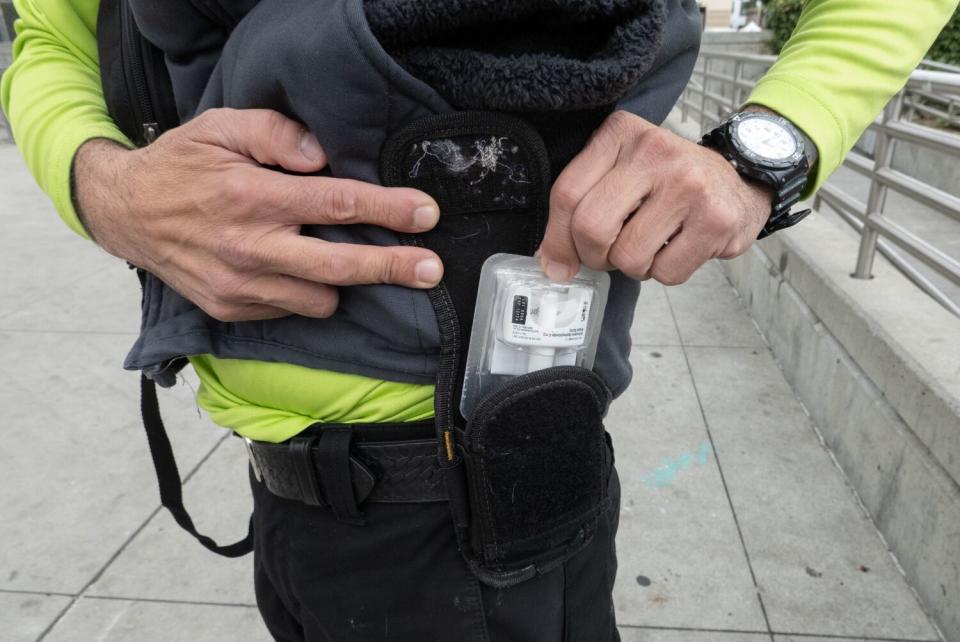 A close-up of a Narcan package held in a hip-mounted holster