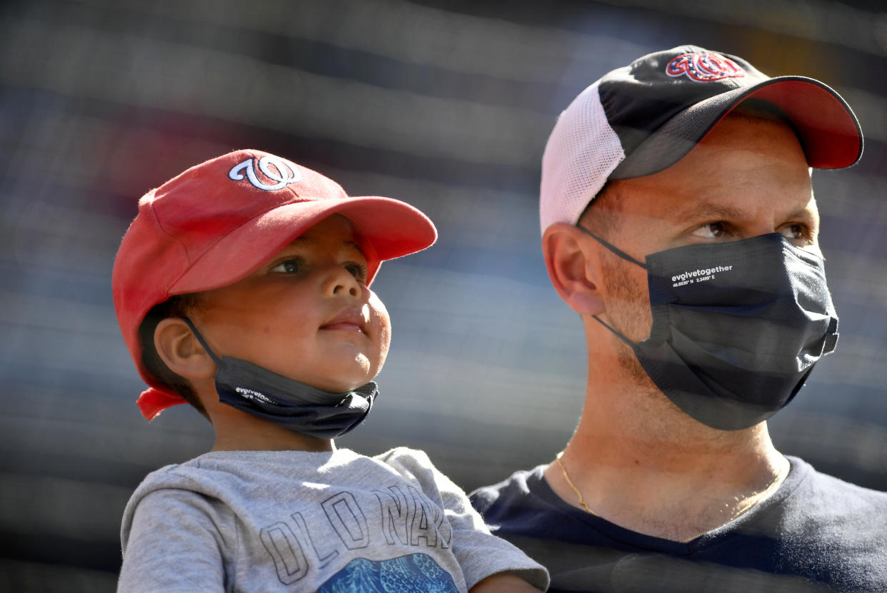 Watching a baseball game wearing face masks. (Randy Litzinger/Icon Sportswire via Getty Images)