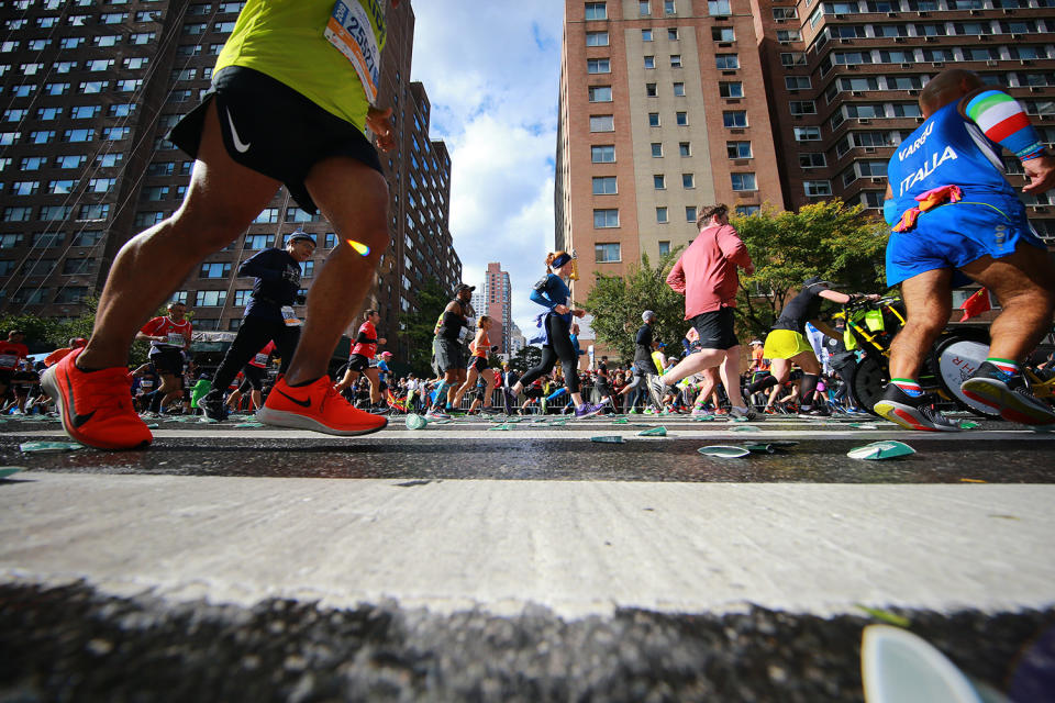 Runners step on used water cups discarded on the street during the 2019 New York City Marathon, Nov. 3, 2019. (Photo: Gordon Donovan/Yahoo News) 