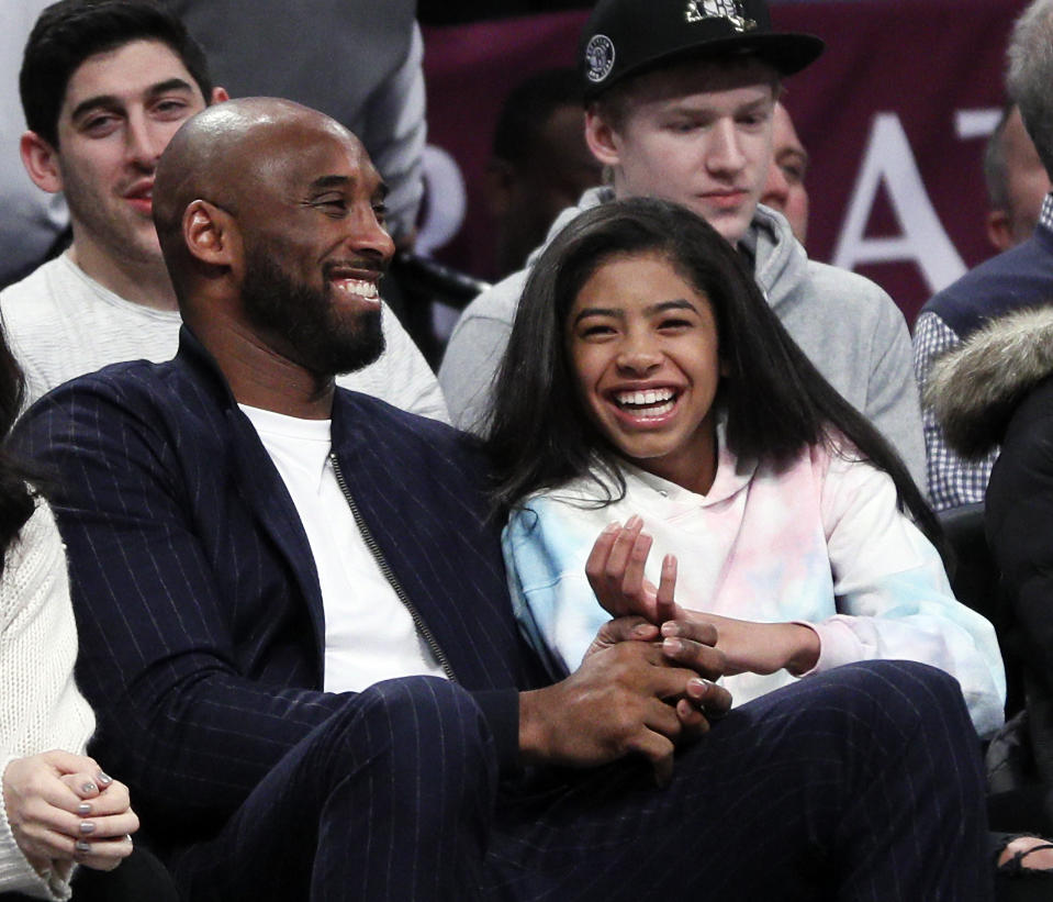 Kobe Bryant and his daughter Gigi, watch an NBA basketball game between the Brooklyn Nets and Atlanta Hawks on December 21, 2019 at Barclays Center in New York City. (Photo by Paul Bereswill/Getty Images)