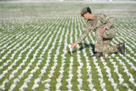 <p>Captain James Pugh places a figure among the installation Shrouds of the Somme (Photo from Kirsty O’Connor/PA) </p>