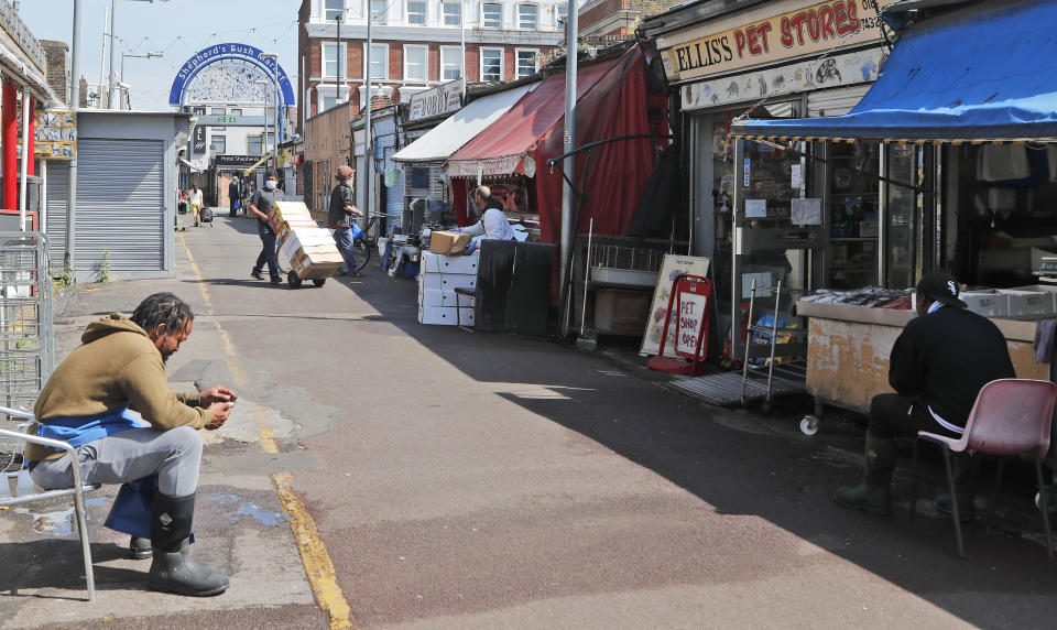 Shop owners wait for customers and prepare at Sherpherd's Bush Market in London, Wednesday, May 27, 2020. Following the gradual easing of the COVID-19 lockdown, street markets will be allowed to reopen in Britain from Monday onwards. (AP Photo/Frank Augstein)