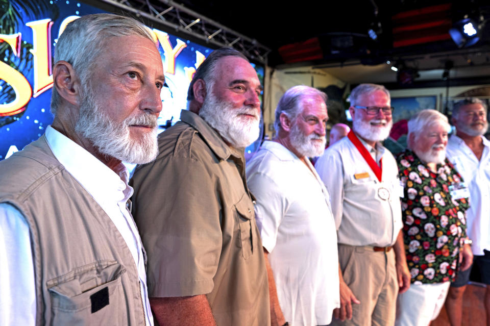 In this photo provided by the Florida Keys News Bureau, Hank Wielgosz, left, tries to impress the judges during the first preliminary round of the "Papa" Hemingway Look-Alike Contest at Sloppy Joe's Bar in Key West, Fla., Thursday, July 20, 2023. Wielgosz, a Melbourne, Fla., resident, is competing for the 29th year and has advanced to the finals set for Saturday, July 22. Thursday's contest, staged on the eve of Ernest Hemingway's 124th birthday anniversary, was the first of two preliminary rounds of the competition, a featured event of Key West's annual Hemingway Days festival. Honoring the late author who lived and wrote in Key West throughout most of the 1930s, the festival is to end Sunday, July 23. (Andy Newman/Florida Keys News Bureau via AP)