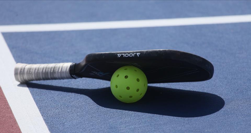 A pickleball paddle and ball sit on a court during the Minto US Open Pickleball Championships in April 2023. The sport is growing fast, with permanent courts being approved to be built at Salina's Oakdale Park.