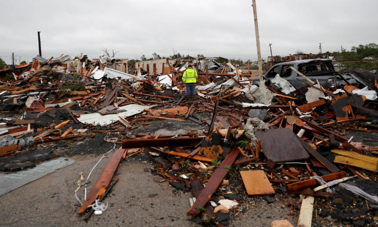 <span>A man is surrounded by tornado damage after severe storms moved through the night before in Sulphur, Oklahoma, on 28 April 2024.</span><span>Photograph: Bryan Terry/AP</span>