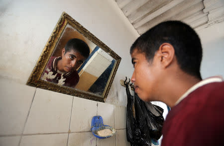 Palestinian songbird catcher Hamza Abu Shalhoub, 16, is reflected in a mirror as he washes at his family house in Rafah in the southern Gaza Strip November 8, 2018. Picture taken November 8, 2018. REUTERS/Ibraheem Abu Mustafa