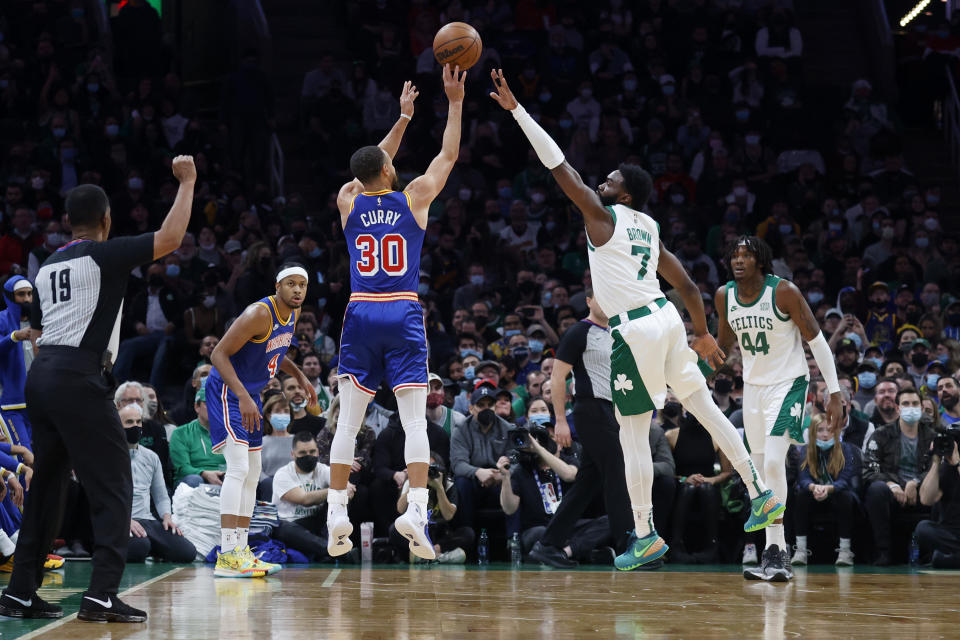 Golden State Warriors guard Stephen Curry (30) shoots a three-point basket over Boston Celtics guard Jaylen Brown (7) during the first half of an NBA basketball game, Friday, Dec. 17, 2021, in Boston. (AP Photo/Mary Schwalm)