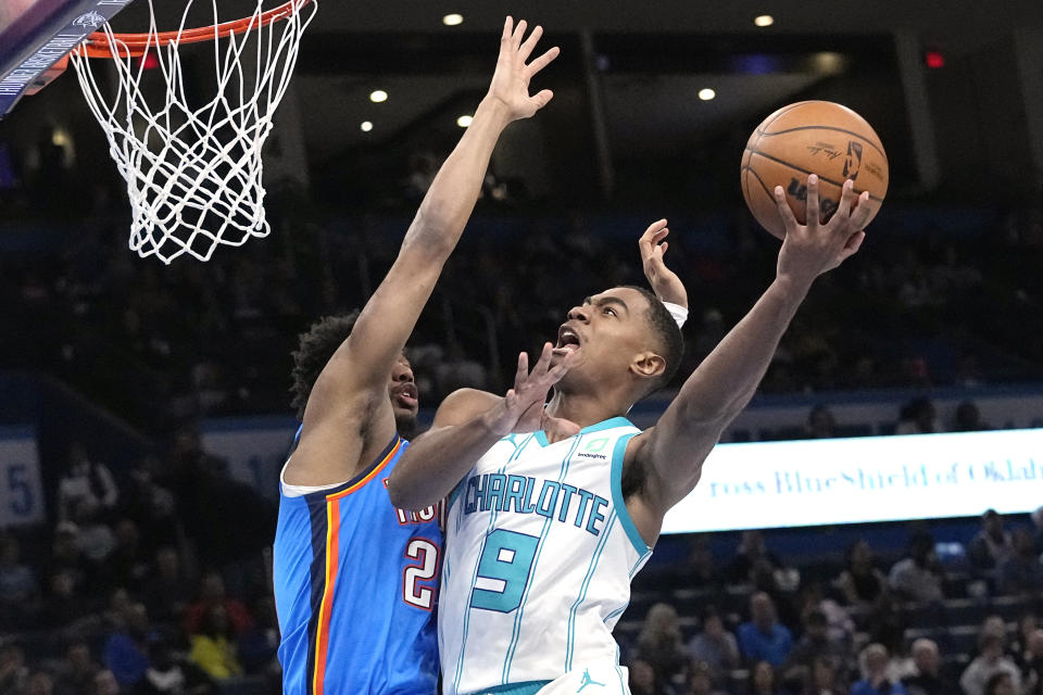 Charlotte Hornets guard Theo Maledon (9) shoots as Oklahoma City Thunder guard Aaron Wiggins, left, defends in the first half of an NBA basketball game Tuesday, March 28, 2023, in Oklahoma City. (AP Photo/Sue Ogrocki)