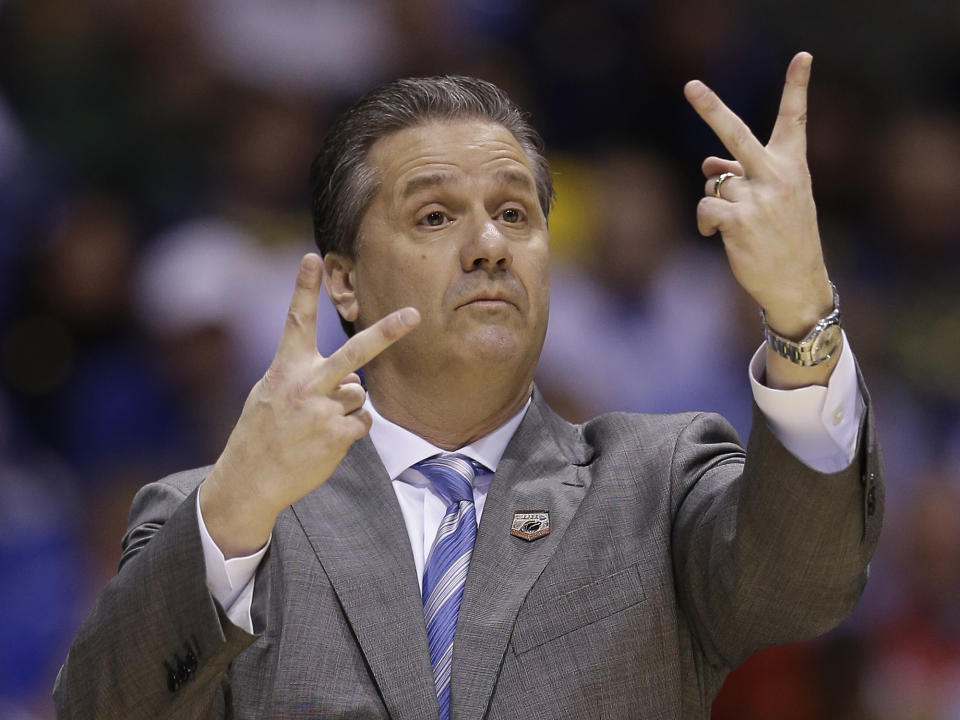 Kentucky head coach John Calipari signals during the first half of an NCAA Midwest Regional semifinal college basketball tournament game against the Louisville Friday, March 28, 2014, in Indianapolis. (AP Photo/David J. Phillip)