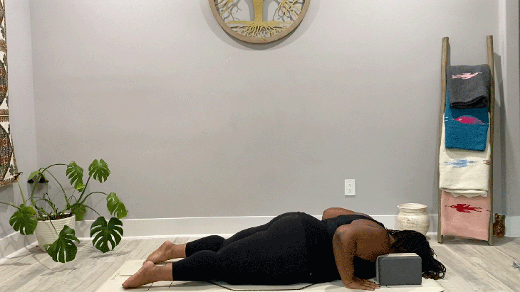 Woman lying on her belly on her yoga mat doing a slow flow