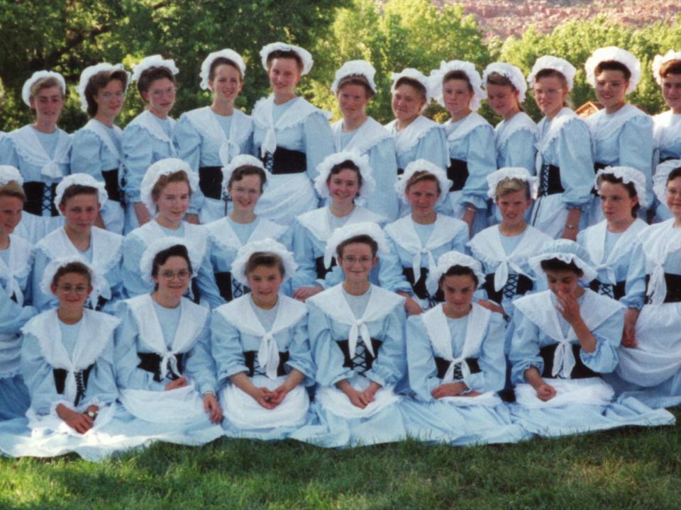 Scores of women belonging to the FDLS appear in a group portrait which shows them wearing their trademark prairies dresses.