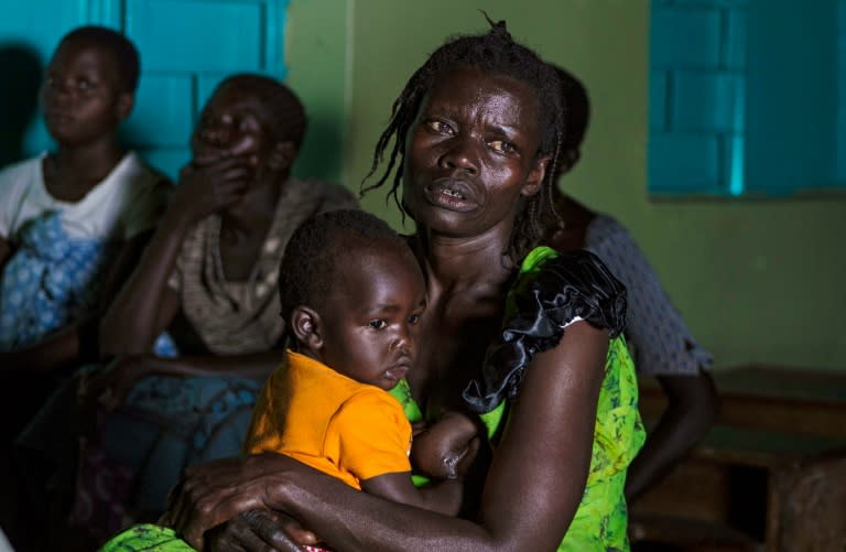 Ugandans living in the Lukodi disctrict of Gulu follow the live broadcast of Dominic Ongwen appearance before the International Criminal Court at The Hague, on January 21, 2016