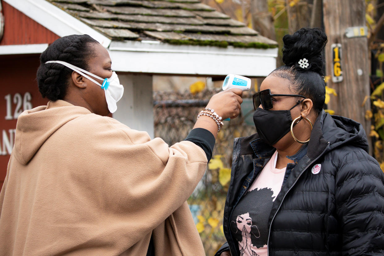 A volunteer checks temperatures before a training session as part of an outreach program to the Black community to increase vaccine trial participation in Rochester, New York, U.S., November 14, 2020. Picture taken November 14, 2020.  REUTERS/Lindsay DeDario