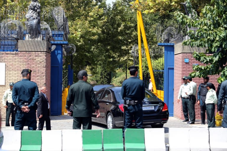 Iranian security forces stand guard as Philip Hammond arrives in his car at the British embassy in Tehran on August 23, 2015