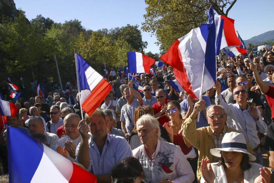 FILE - In this Saturday, Oct. 8, 2016 file photo, supporters of far right National Front party attend a rally in Pierrefeu, southeastern France. If Marine Le Pen has her way, the French will soon pay for their baguettes with francs, not euros. The presidential candidate from the anti-EU, anti-immigration National Front party is all about national sovereignty and independence. She wants France to take control of its money, subject to a referendum that would lead France out of the European Union and its shared currency. (AP Photo/Philippe Farjon, file)