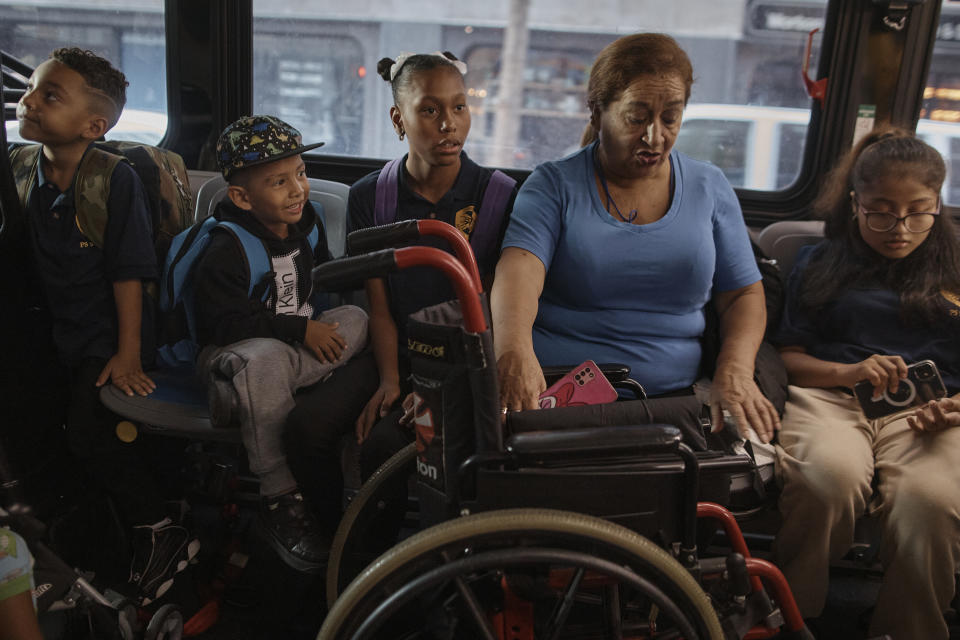 Damien Salinas, 5 years old, second left, rides the bus on his way to school on Thursday, Sept. 7, 2023, in New York. Damien attends his first day of school in New York City after his family emigrated from Ecuador in June. Damien and her family have been living in a room at the historic Roosevelt Hotel, converted into a city-run shelter for newly arrived migrant families hoping to find work, a new home and a better life for their children. (AP Photo/Andres Kudacki)