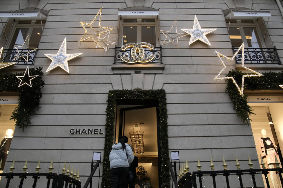 A woman enters a Chanel boutique Wednesday, Dec. 15, 2021 in Paris. The French luxury fashion house Chanel has chosen Leena Nair, an industry outsider from India and longtime executive at Unilever, to be its new CEO. (AP Photo/Christophe Ena)