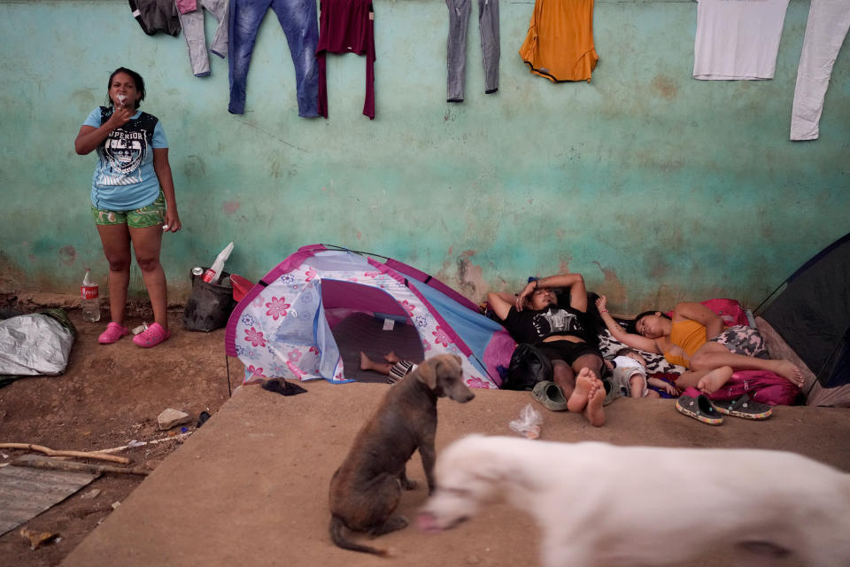 One migrant washes her teeth as other sleep after a trip on foot through the jungle in Bajo Chiquito, Darien Province, Panama Sunday, May 7, 2023. (AP Photo/Natacha Pisarenko)