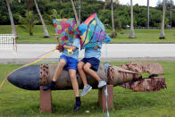 <p>Pupils sit on the World War II remnants of a torpedo at Asan Memorial Park on the island of Guam, a U.S. Pacific Territory, August 11, 2017. (Erik De Castro/Reuters) </p>