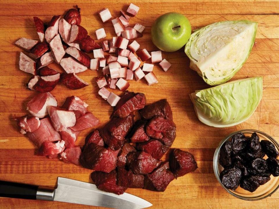 Chopped ingredients for Bigos—a polish venison stew recipe—arranged on a cutting board.