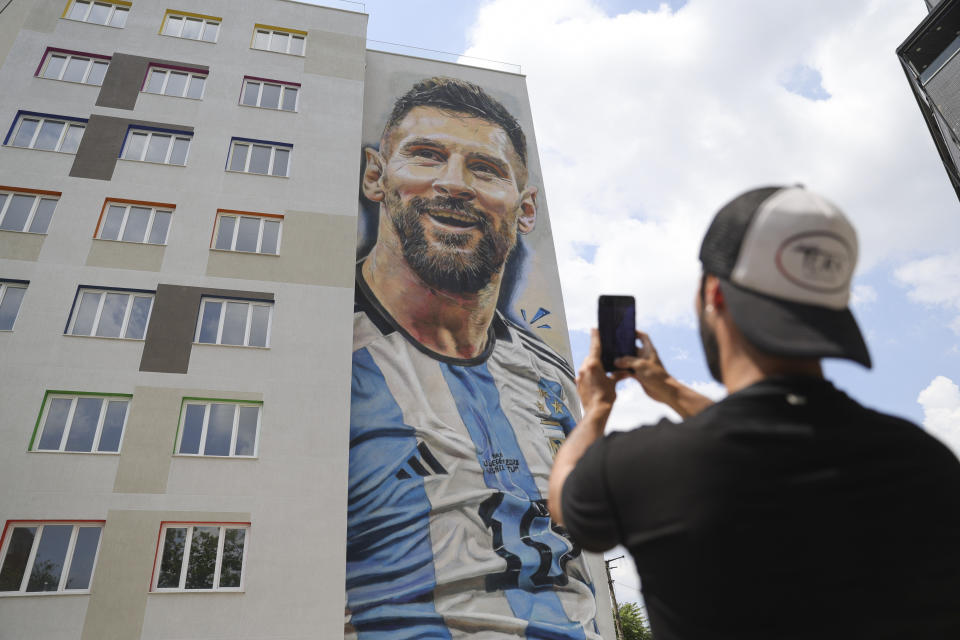 Argentinian street artist Maximiliano Bagnasco takes a photo of a mural portraying Argentinian soccer superstar Lionel Messi, that he painted, in Tirana, Albania, on Thursday, June 8, 2023. The 25x10 meters Messi's mural is part of the Tirana MuralFest 2023. (AP Photo/Llazar Semini)