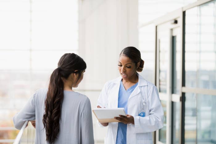 Two healthcare professionals discussing over a tablet