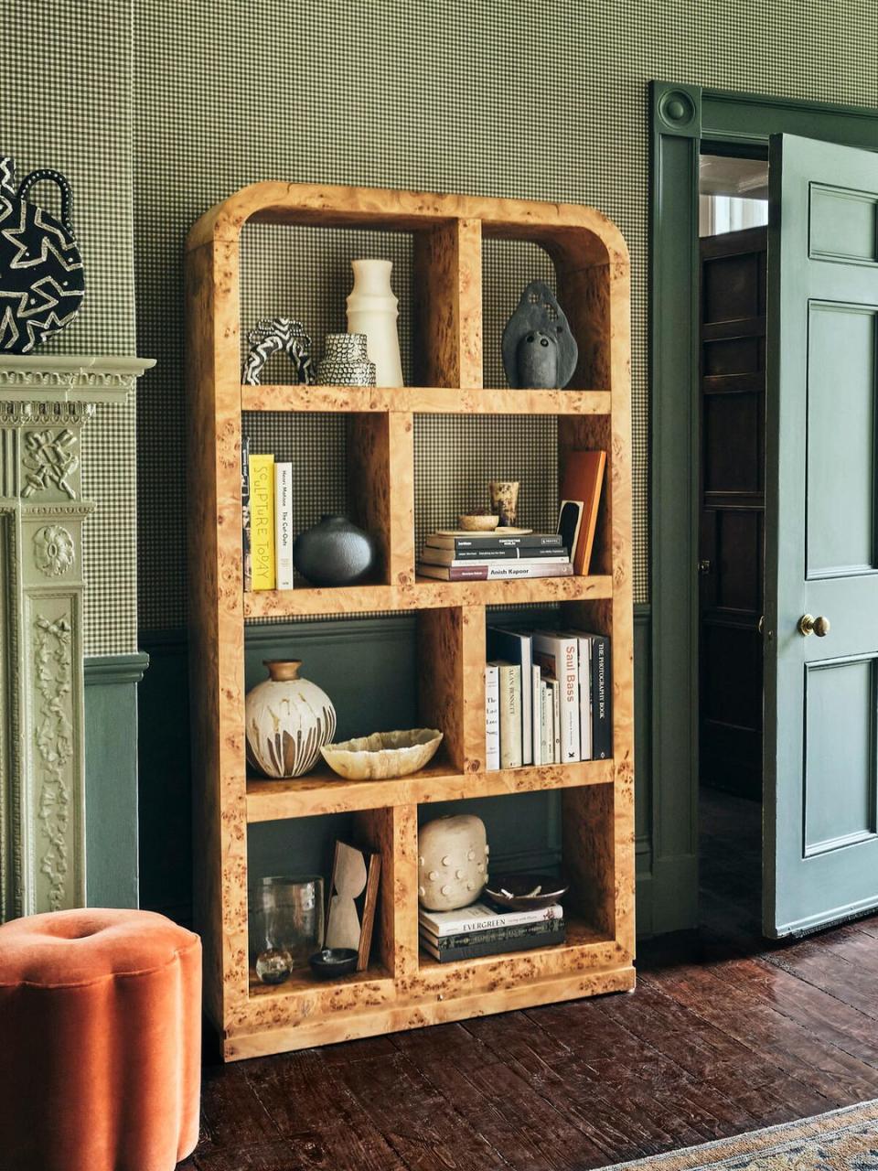 a wooden shelving unit with books and vases