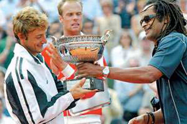 Ferrero recibiendo el trofeo de manos de Yannick Noah; detrás, observa Verkerk