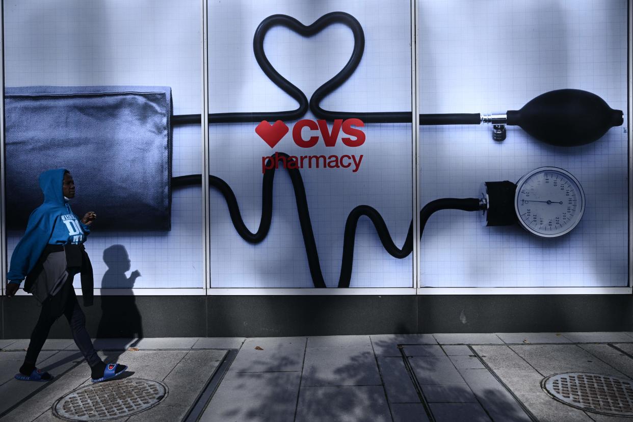 A woman walks past a CVS Pharmacy in Washington, DC, on November 2, 2022. (Photo by BRENDAN SMIALOWSKI/AFP via Getty Images)