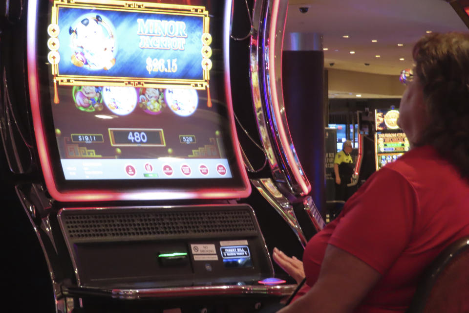 A gambler plays a slot machine at Harrah's casino in Atlantic City N.J. on Sept. 29, 2023. Atlantic City faces challenges in the new year including a potential smoking ban in its nine casinos, and their quest to return to pre-pandemic business levels. (AP Photo/Wayne Parry)