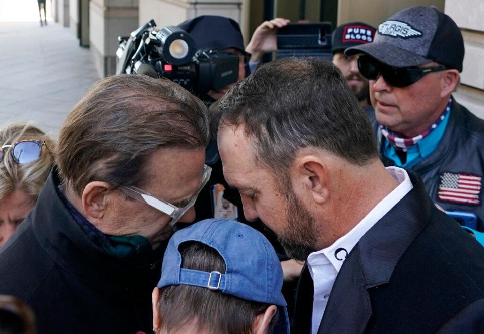 Otero County, New Mexico Commissioner Couy Griffin, right, prays before entering the Federal Court House in Washington, Monday, March. 21, 2022. Griffin is charged with illegally entering Capitol grounds the day a pro-Trump mob disrupted certification of Joe Biden's presidential election victory on Jan. 6, 2021.