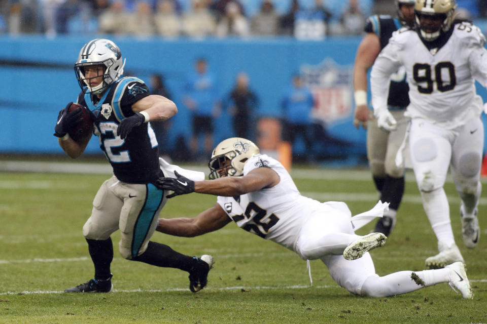 Carolina Panthers running back Christian McCaffrey (22) breaks a tackle by New Orleans Saints linebacker Craig Robertson (52) during the second half of an NFL football game in Charlotte, N.C., Sunday, Dec. 29, 2019. McCaffrey broke a record on the play to become the third player in NFL history to tally 1000 rushing and 1000 receiving yards in the same season. (AP Photo/Brian Blanco)