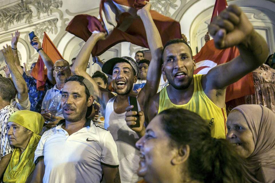 Tunisians celebrate the exit polls indicating a vote in favor of the new Constitution, in Tunis, late Monday, July 25, 2022. Hundreds of supporters of Tunisian President Kais Saied took to the streets to celebrate after the end of voting on a controversial new constitution that critics say could reverse hard-won democratic gains and entrench a presidential power grab. (AP Photo/Riadh Dridi)