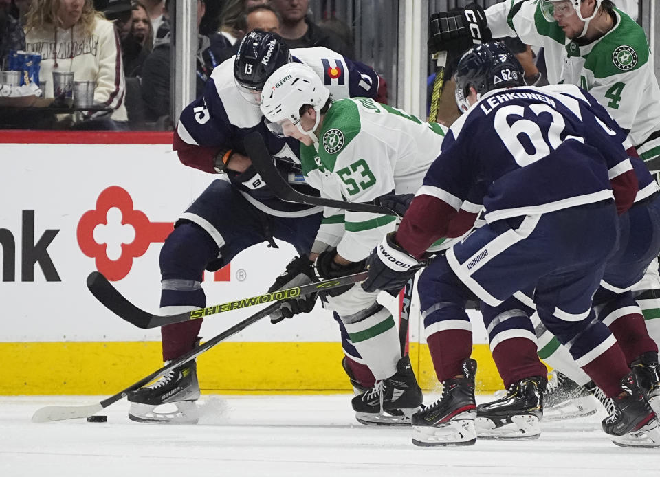 Dallas Stars center Wyatt Johnston (53) battles for control of the puck with Colorado Avalanche right wing Valeri Nichushkin, left, and left wing Artturi Lehkonen (62) in the second period of an NHL hockey game Sunday, April 7, 2024, in Denver. (AP Photo/David Zalubowski)