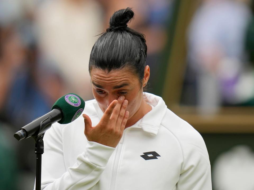 Ons Jabeur wipes tears from her eyes after losing in the 2023 Wimbledon final.