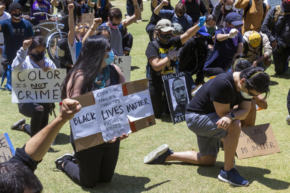 Demonstrators kneel down for 8 minutes and 46 seconds Thursday, June 4, 2020, in downtown Los Angeles during a protest over the death of George Floyd, who died May 25 after being restrained by police in Minneapolis. (AP Photo/Damian Dovarganes)