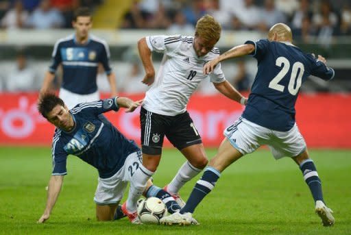 Germany's midfielder Mario Goetze (C), Argentina's Pablo Guinazu (L) and Argentina's Rodrigo Brana vie for the ball during the friendly football match Germany vs Argentina in Frankfurt am Main, western Germany. Argentina won 3-1