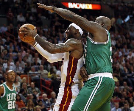 Miami Heat's LeBron James (C) tries to shoot over Boston Celtics' Shaquille O'Neal during the second quarter of NBA basketball action in Miami November 11, 2010. REUTERS/Hans Deryk