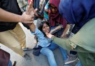 Woman reacts after she was injured during a protest against a new citizenship law, in New Delhi