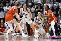 UConn guard Paige Bueckers gestures for a timeout while under pressure from Syracuse guards Georgia Woolley, left, and Dyaisha Fair, right, as teammate Ashlynn Shade (12) looks on in the second half of a second-round college basketball game in the NCAA Tournament, Monday, March 25, 2024, in Storrs, Conn. (AP Photo/Jessica Hill)
