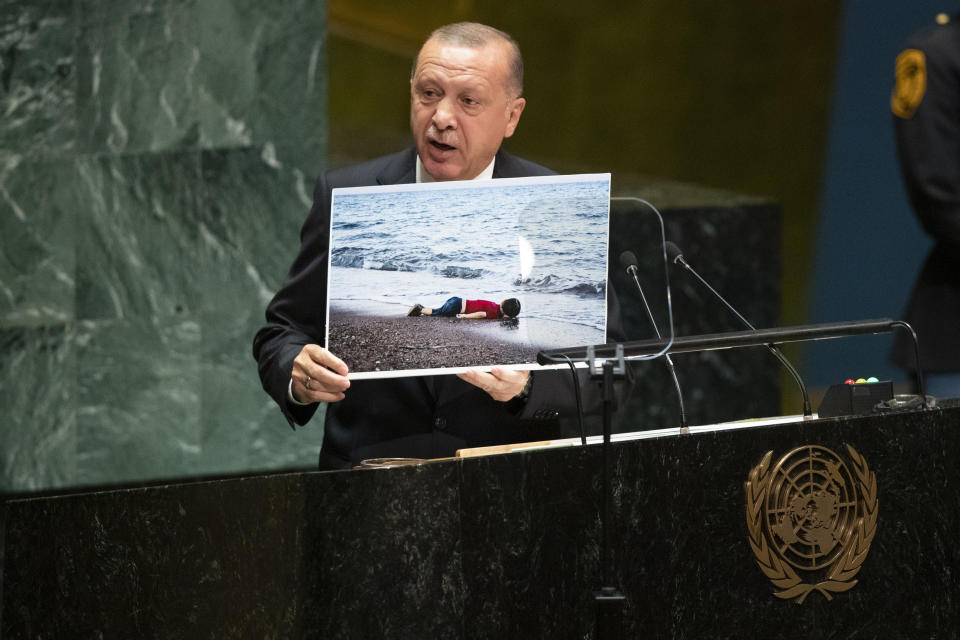 Turkish President Recep Tayyip Erdgan holds up a photograph while addressing the 74th session of the United Nations General Assembly at U.N. headquarters Tuesday, Sept. 24, 2019. (AP Photo/Mary Altaffer)