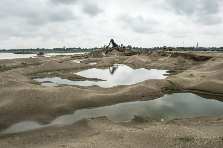 Industrial pipes and excavators suck up the Mekong's floor, carving moon-like craters into the bed of a river that winds through most of the landlocked nation