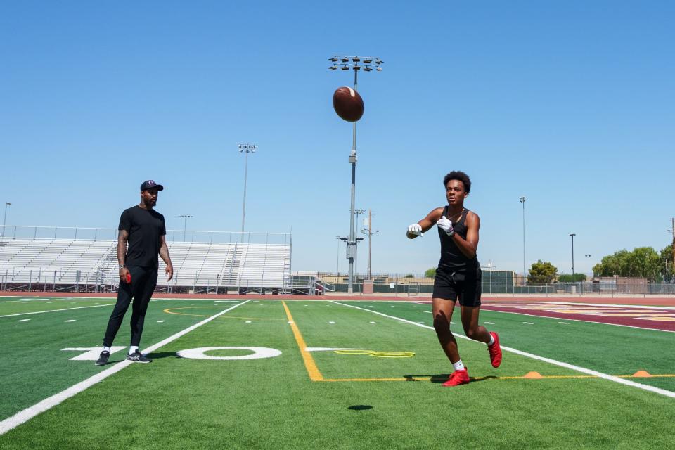 Former NFL wide receiver Jaelen Strong (left) watches Tolleson's Judah Lancaster during a private practice at Tolleson Union High School on June 16, 2023, in Tolleson.