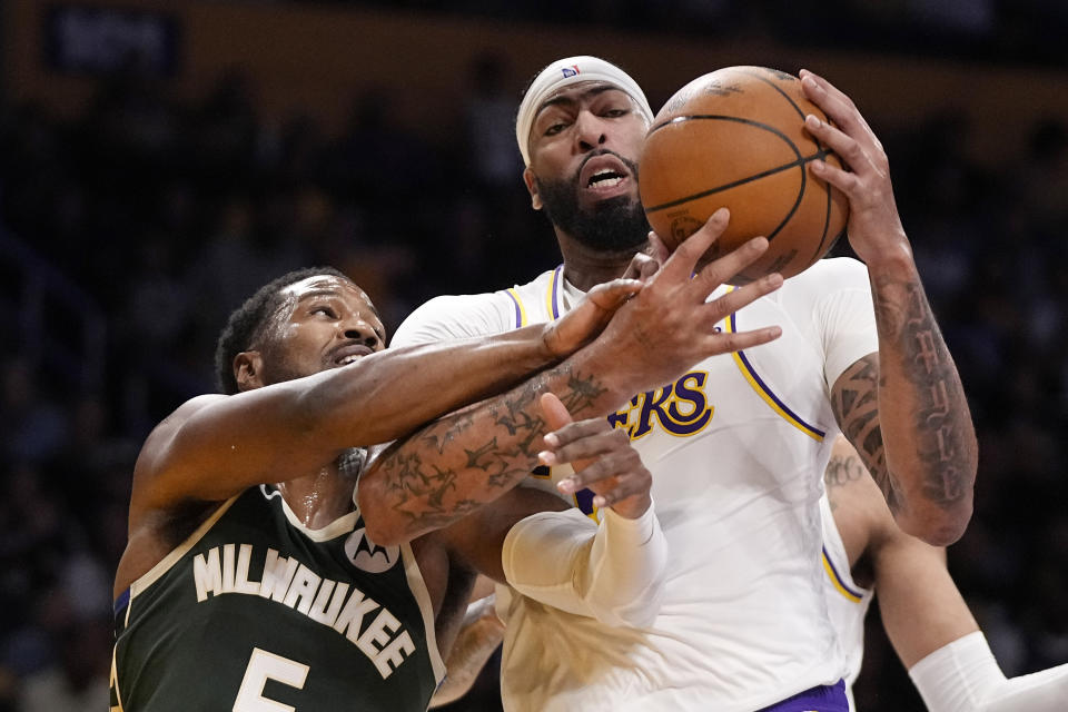 Milwaukee Bucks guard Malik Beasley, left, reaches in on Los Angeles Lakers forward Anthony Davis during the first half of an NBA preseason basketball game Sunday, Oct. 15, 2023, in Los Angeles. (AP Photo/Mark J. Terrill)