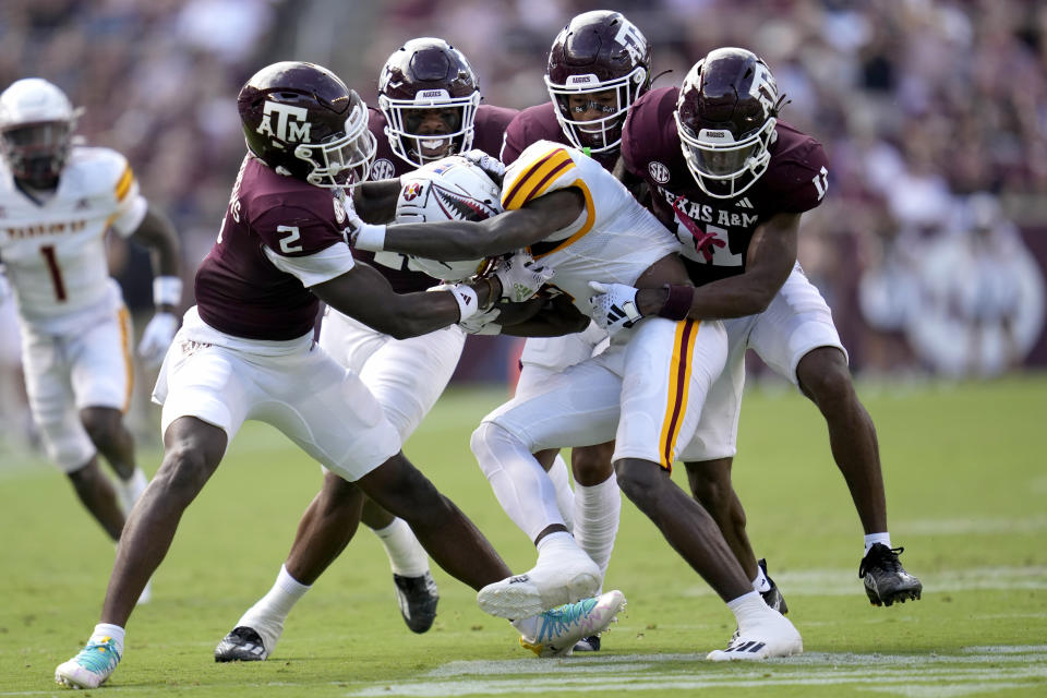 Louisiana-Monroe linebacker Austin Goffney, center front, is swarmed by Texas A&M defenders after catching a ball during the second quarter of an NCAA college football game Saturday, Sept. 16, 2023, in College Station, Texas. (AP Photo/Sam Craft)