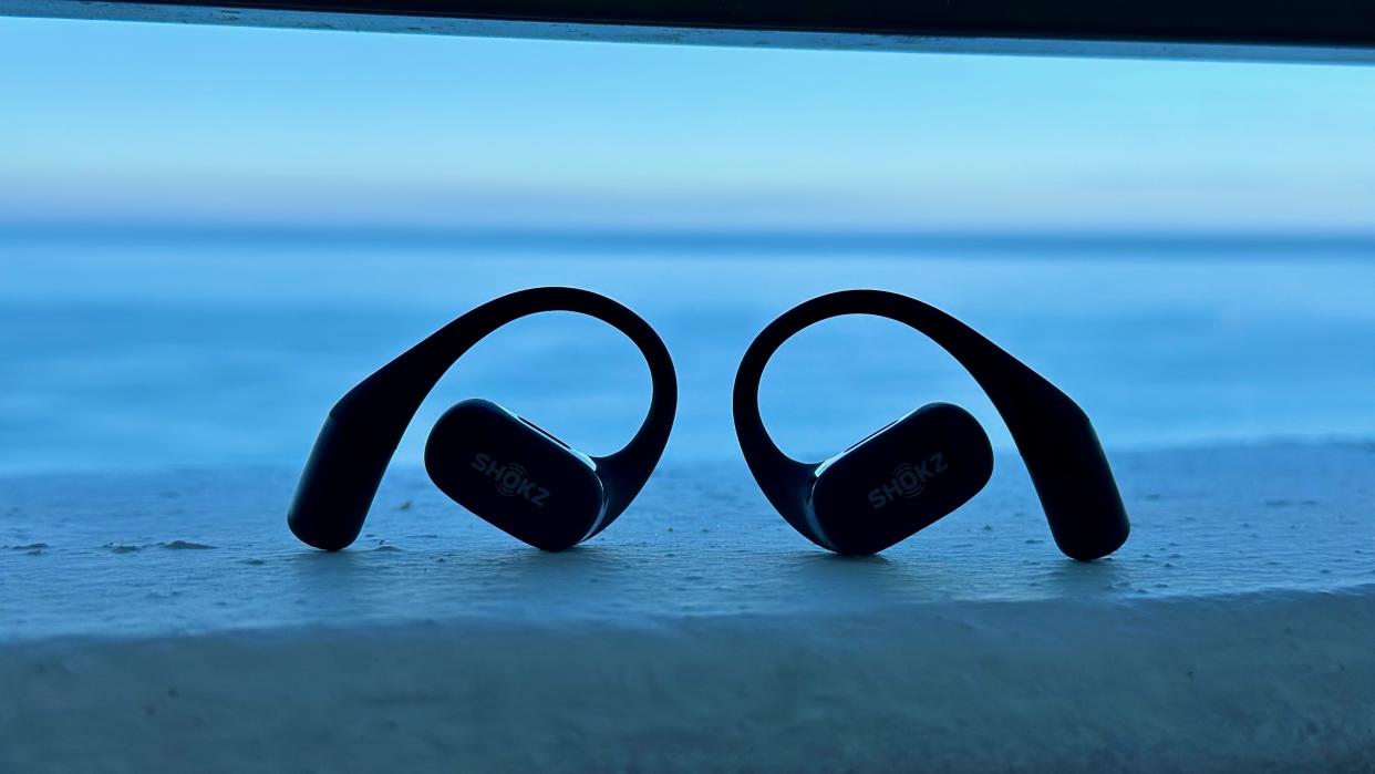  The Shokz OpenFit sitting upright in front of the ocean. 
