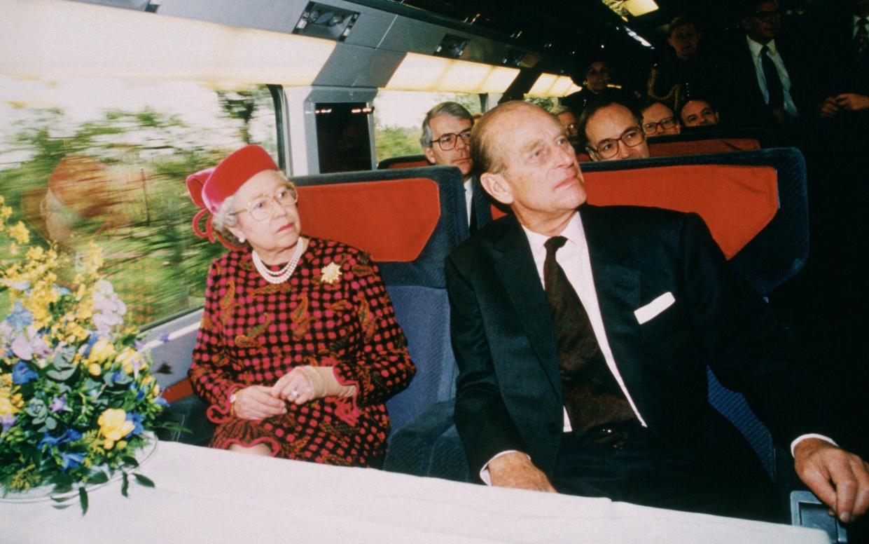 The late Queen and her husband Prince Philip  aboard the Eurostar for the tunnel's inauguration, with former prime minister John Major behind them