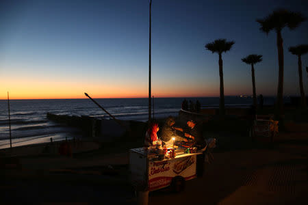A man sells hot dogs next to the fence separating Mexico and the United States, in Tijuana, Mexico. REUTERS/Edgard Garrido