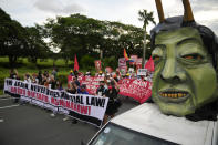 FILE - Human rights groups pass by an effigy of Philippine President Ferdinand Marcos Jr. as they mark the 50th anniversary of martial law at the University of the Philippines in Manila, Philippines on Sept. 21, 2022. Marcos Jr. has reaffirmed ties with the United States, the first major power he visited since taking office in June, in a key turnaround from the often-hostile demeanor his predecessor displayed toward Manila's treaty ally. (AP Photo/Aaron Favila, File)