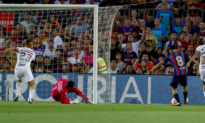 Pedri se apresta a anotar tras eludir al arquero en la victoria 6-0 de Barcelona sobre los Pumas de México en Barcelona el 7 de agosto del 2022. Pedri marcó dos goles, ambos tras ser habilitado por Robert Lewandowski. (AP Photo/Joan Monfort)